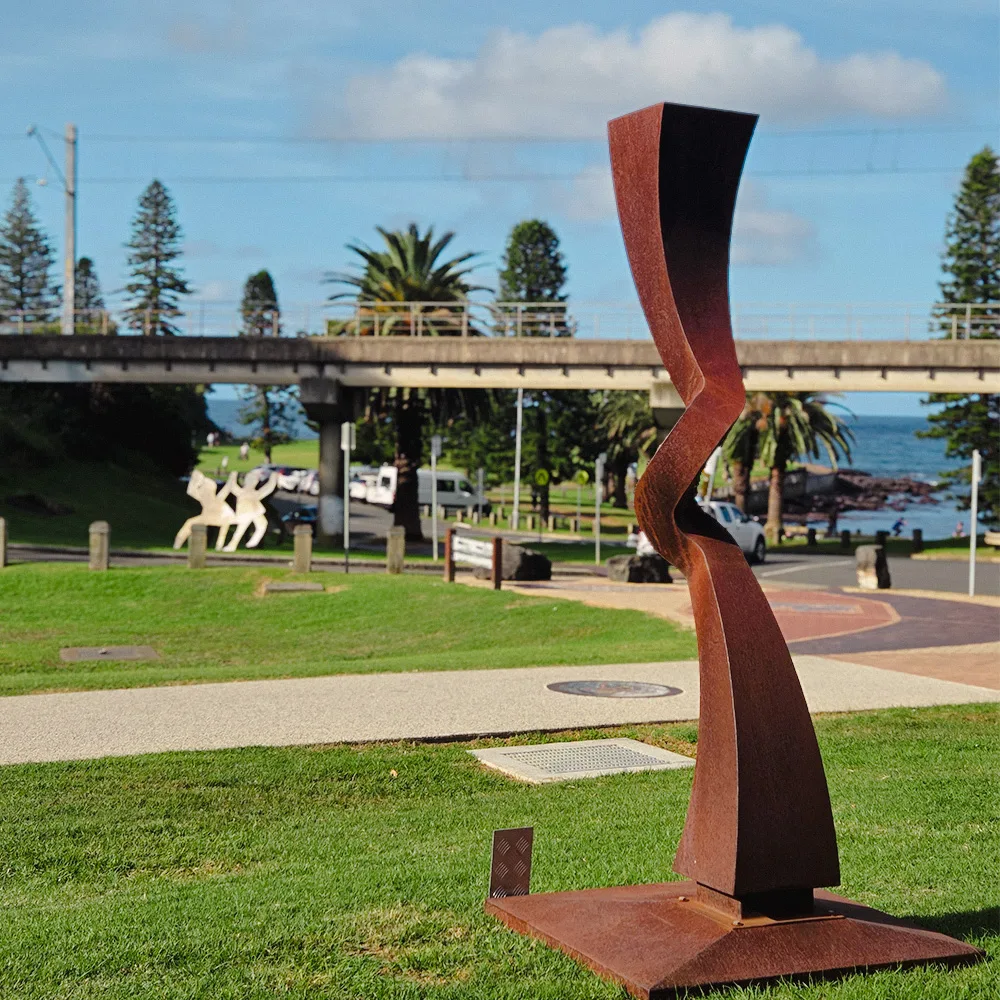 sculpture installation and removal sydney Tall stainless steel totem sculpture installed in a Sydney garden
